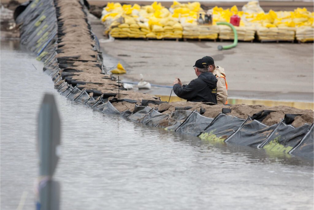 Two people standing behind a river flood barrier in Fargo, North Dakota