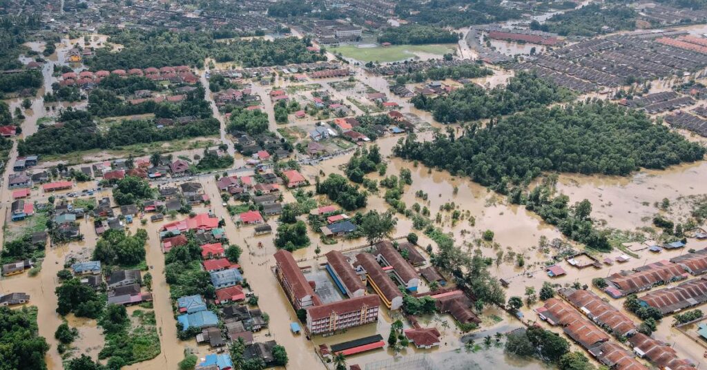 An aerial view of a town flooded by brown water.