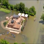 School safely surrounded by flood barriers keeping out water during a severe flood